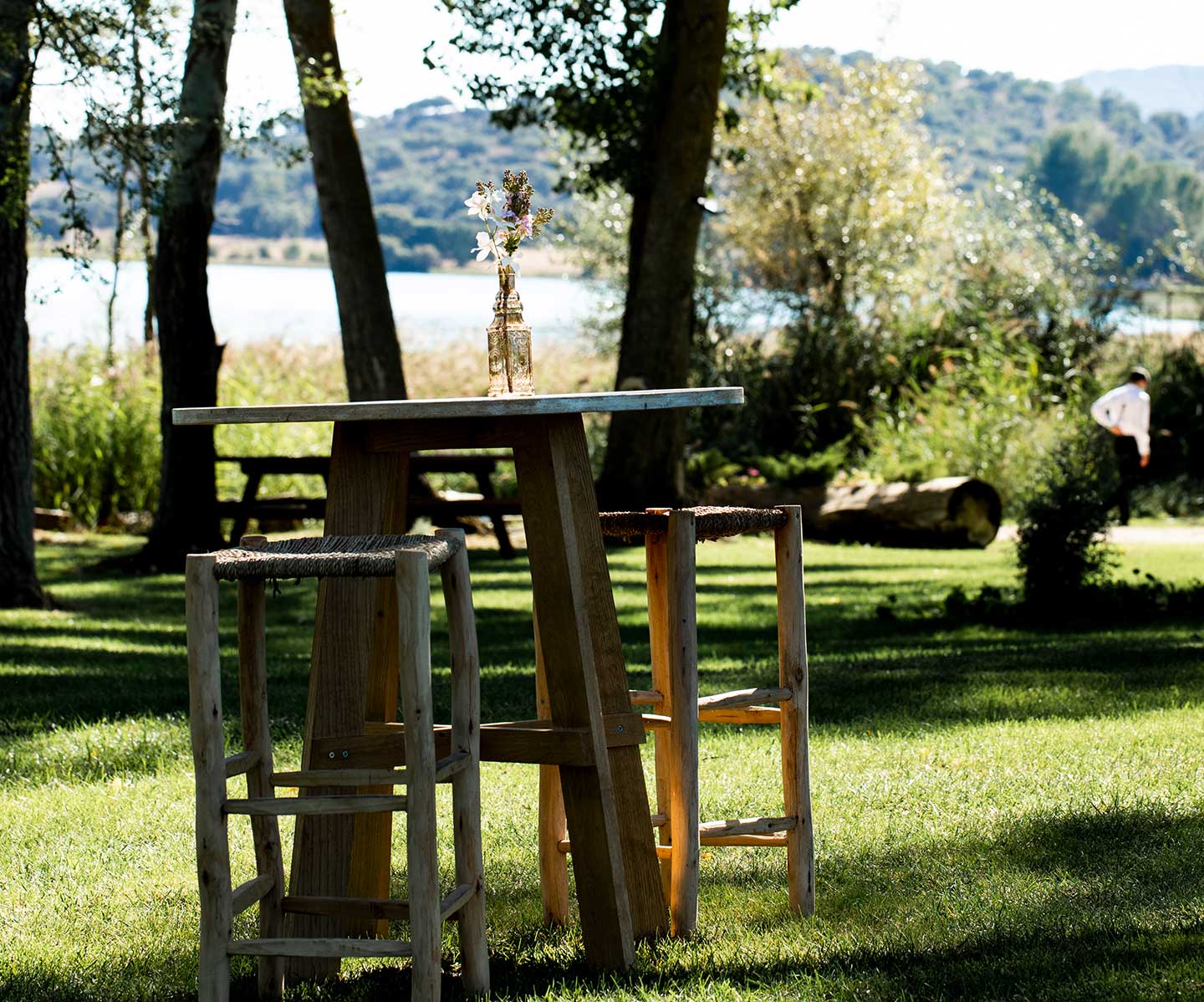Mesa alta en medio del campo con dos taburetes